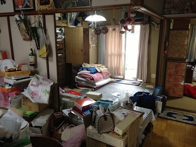 家の間取りは、和室が2部屋、洋室1部屋に台所の3DK。鍵をお預かりし、スタッフ3名9:00より作業開始。押入れには、たくさんの布団、扇風機・アイロンなどの家電品、贈答品、洋服(衣装ケース6箱)、 趣味の道具がぎっしりと つめ込められていました。 布団・衣類・家電品・ガラス製品陶器・道具類・贈答品・プラスチック類に仕分けをして運び出し作業。 もう一部屋の和室には、 すべての引き出しが洋服でいっぱいの大きな洋服タンスが2台。 趣味の作品や調度品飾ってある飾り棚が1台ありました。こちらも、衣類・飾り棚のガラス扉・タンスに付属している鏡(取外し)・ 木製のテーブル・紙類(本・新聞紙)に仕分けをして運び出し作業。台所にかけては、冷蔵庫、電子レンジ 食器棚、ダイニングテーブル、食品類が中心にありました。家電品・陶器・ガラス・木製品に仕分けを行います。缶詰や飲料類は、すべて中身をだして缶・瓶・ペットボトルに仕分けます。 洋室には、健康器具、空気清浄器といった家電品のほか、洋服タンス(中)が1台、3段ボックスなどありました。 こちらの仕分け作業中には、アルバム、パスポート、現金などの貴重品がタンスの引き出しから見つけ出すことができました。 当社では、作業中に見つかった貴重品や探し物が見つかったものは、思い出BOXへ厳重に保管しています。 また、作業中に必要なのか不要なのか判断に迷ったものは、随時電話にてご連絡をしています。 ベランダには、趣味の道具や作品が詰められた段ボールが20箱のほか、未使用ままの掃除機、壊れたストーブなどが積み重ねられている状態でした。 2年間、雨風に打たれた段ボールの一部はボロボロに劣化していました。 すべてものを運び出した後、しっかり清掃作業を行いました。 16:00作業完了。 作業時間6時間 スタッフ3名
